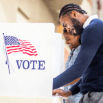 Photo of two people voting in voting booths