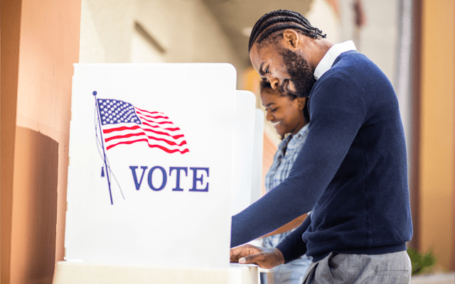 Photo of two people voting in voting booths