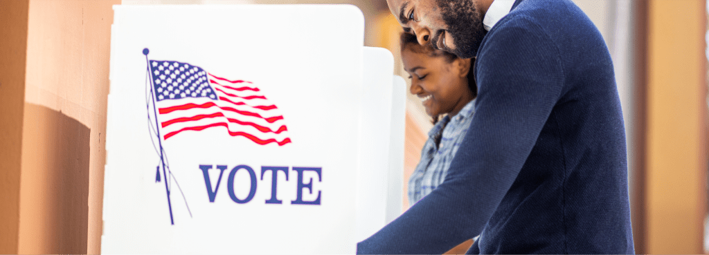 Photo of two people voting in voting booths
