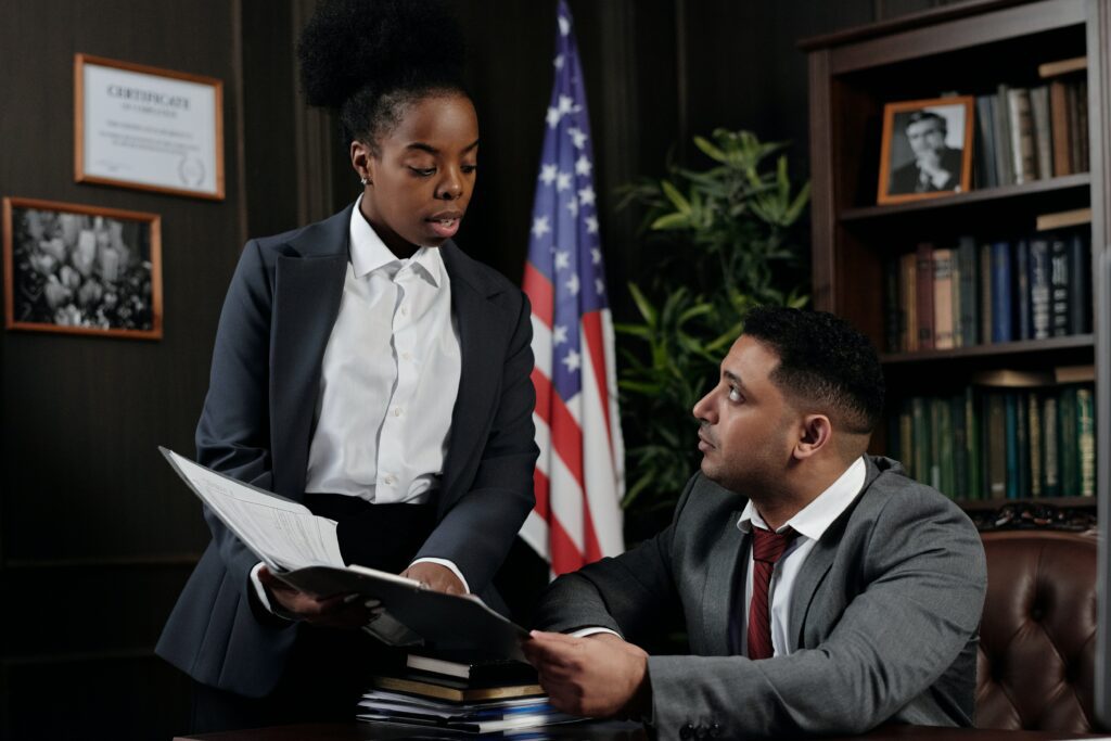 Photo of a woman showing a document to a man in an office