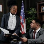 Photo of a woman showing a document to a man in an office