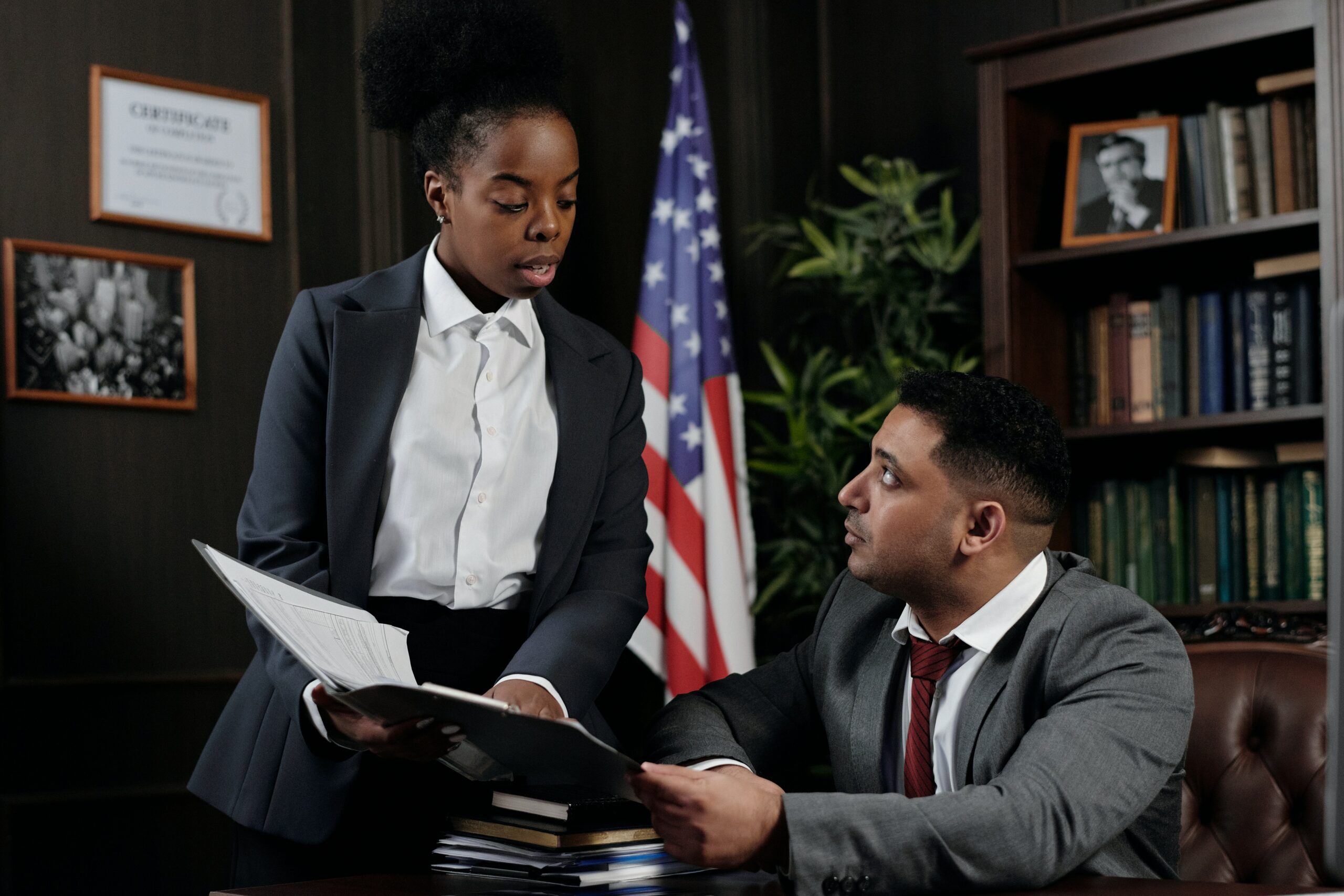 Photo of a woman showing a document to a man in an office