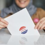 Photo of a woman placing her ballot in a ballot box