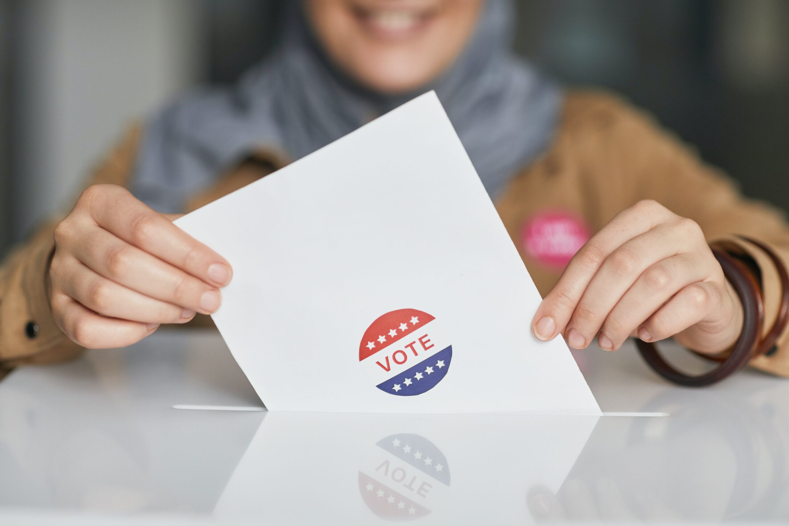 Photo of a woman placing her ballot in a ballot box
