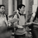 Photo of three college students walking and smiling