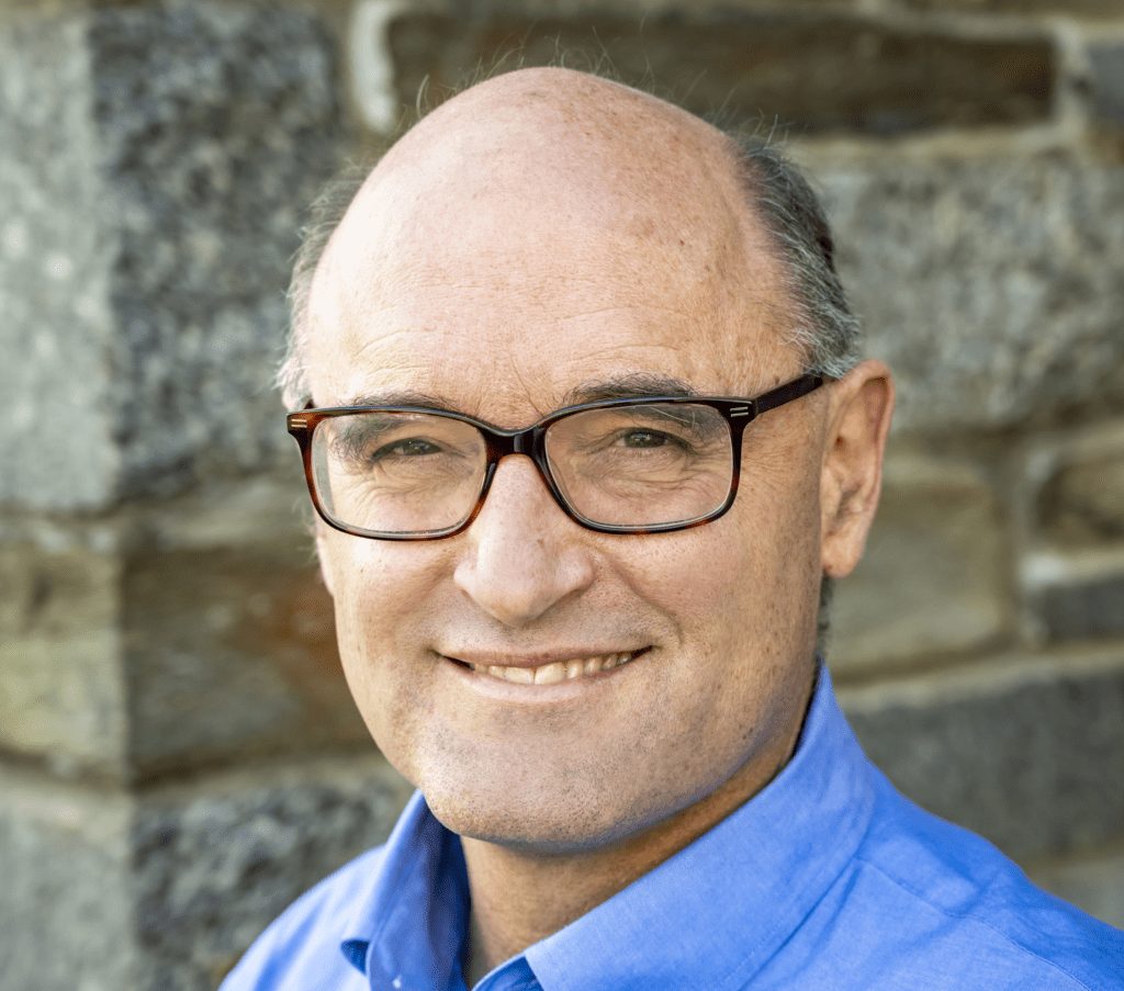 Headshot of FairVote staff member Rob Richie in front of a brick building