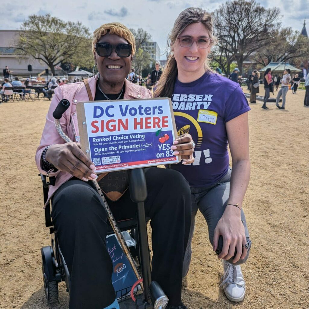 Photo of Andrea Jenkins holding a sign in support of the Make All Votes Count DC campaign