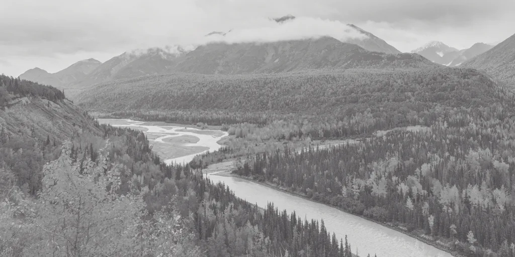 Photo of a mountain range and river in Alaska